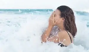 Mulher tomando banho na água do mar