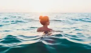 Mulher tomando banho no mar